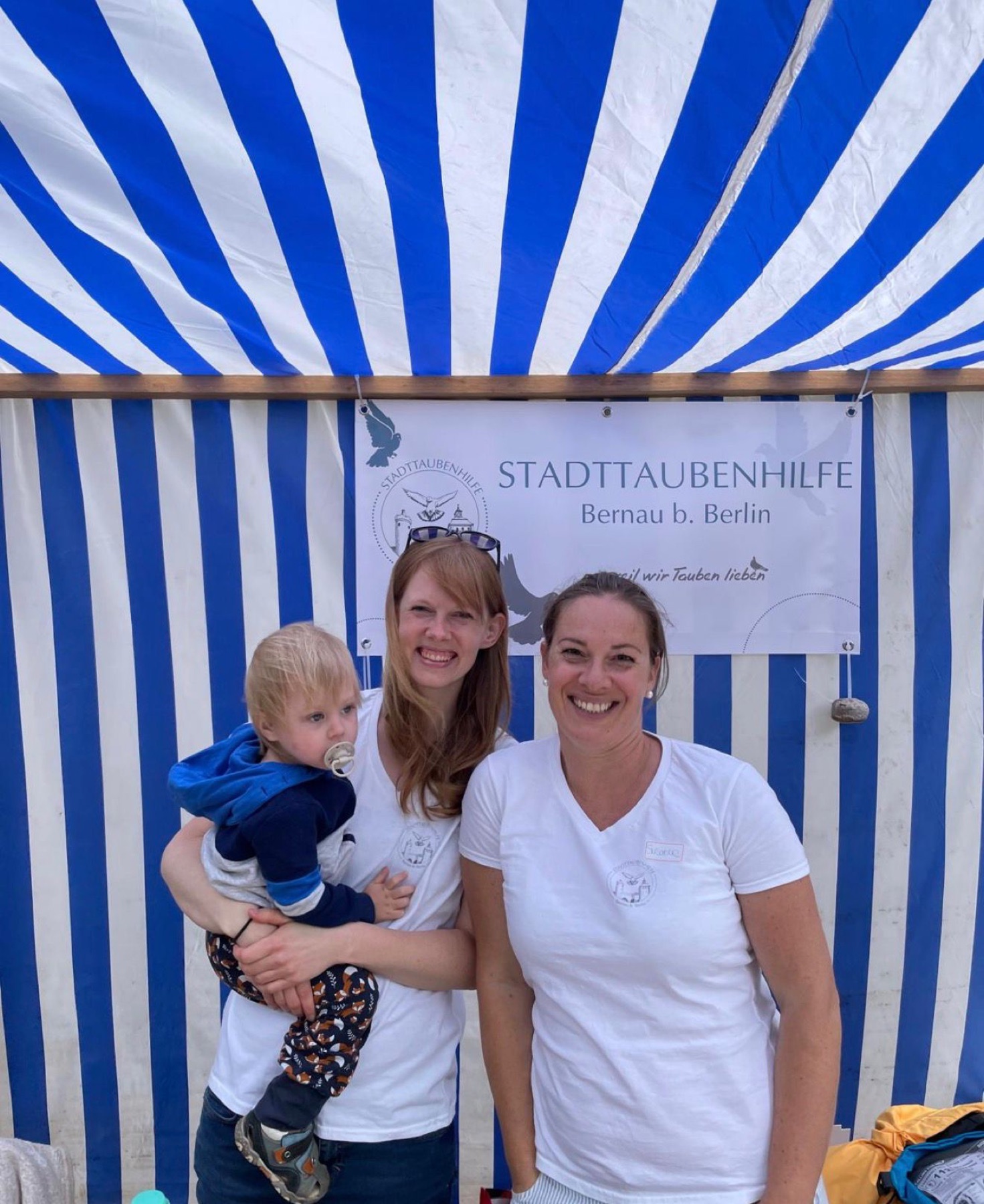 Vereinsmitglieder am Infostand mit Kind